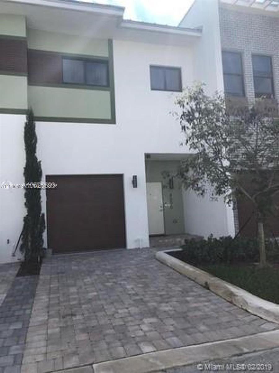 A two-story townhouse features a brown garage door, a white facade, and a paved driveway — 4500 NW 8th Pl, Plantation FL 33317, PLANTATION, FL