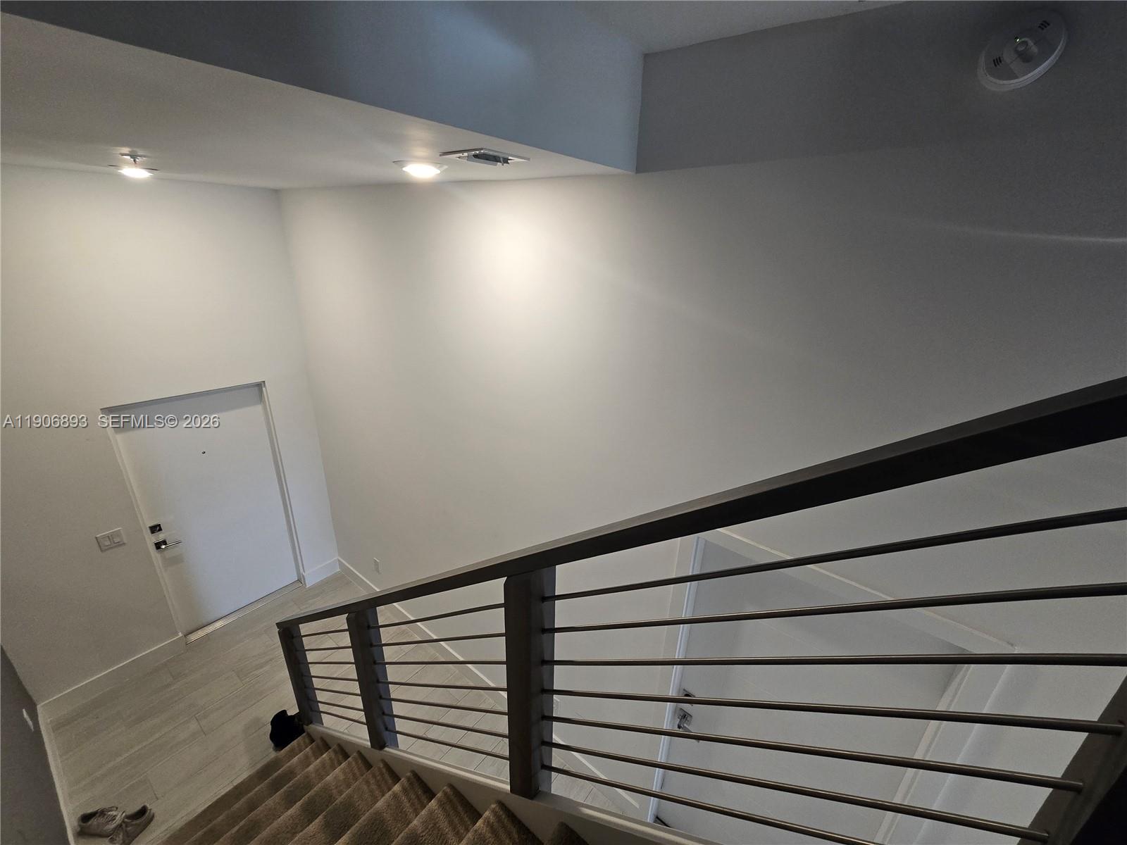 A high-angle view shows a staircase with metal railings leading down to a white door — 4500 NW 8th Pl, Plantation FL 33317, PLANTATION, FL