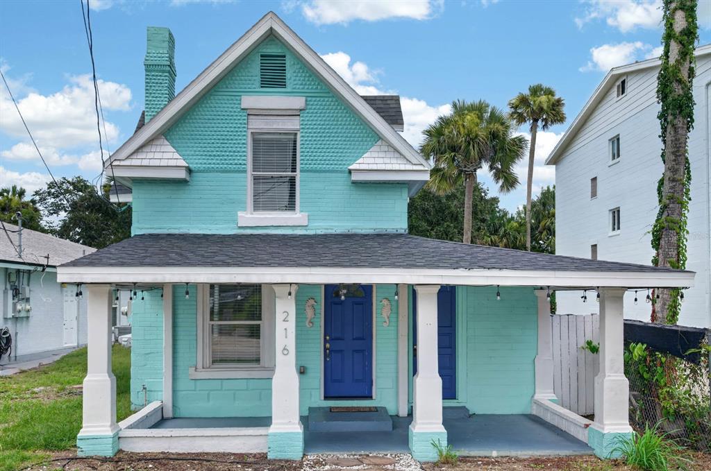 A two-story turquoise house with a front porch, white columns, and a blue front door — 216 N HALIFAX AVENUE, DAYTONA BEACH, FL