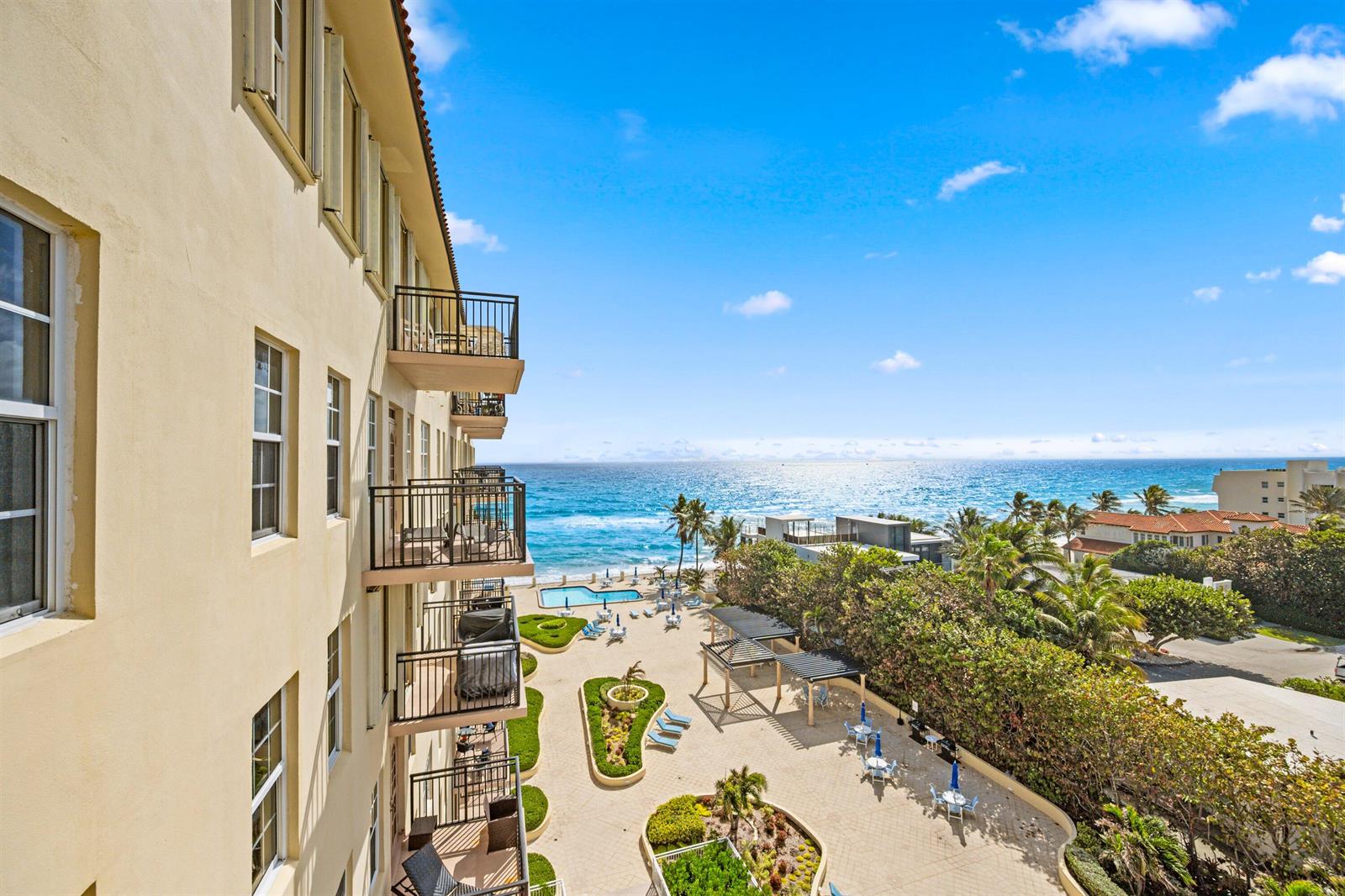An elevated view shows a multi-story building with balconies overlooking a pool and the ocean — 3475 S Ocean Boulevard S Unit 705, Palm Beach FL 33480, PALM BEACH, FL