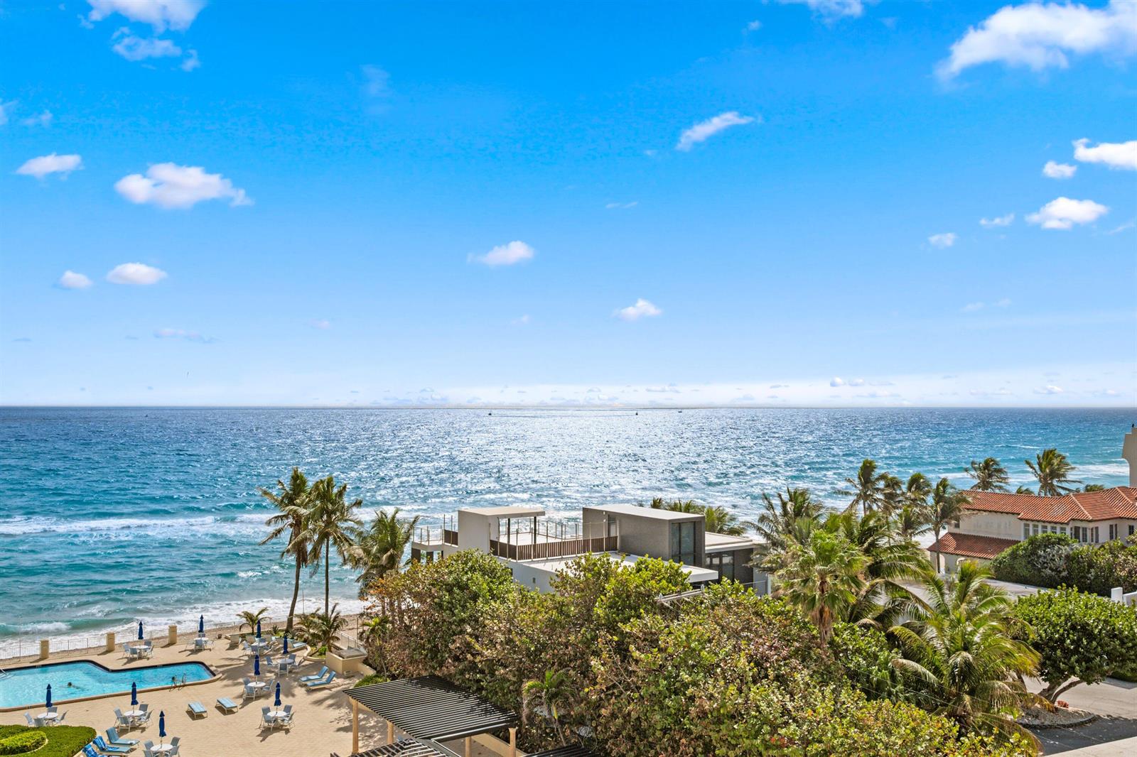 An elevated view of a beach, a swimming pool, palm trees, and modern coastal homes — 3475 S Ocean Boulevard S Unit 705, Palm Beach FL 33480, PALM BEACH, FL