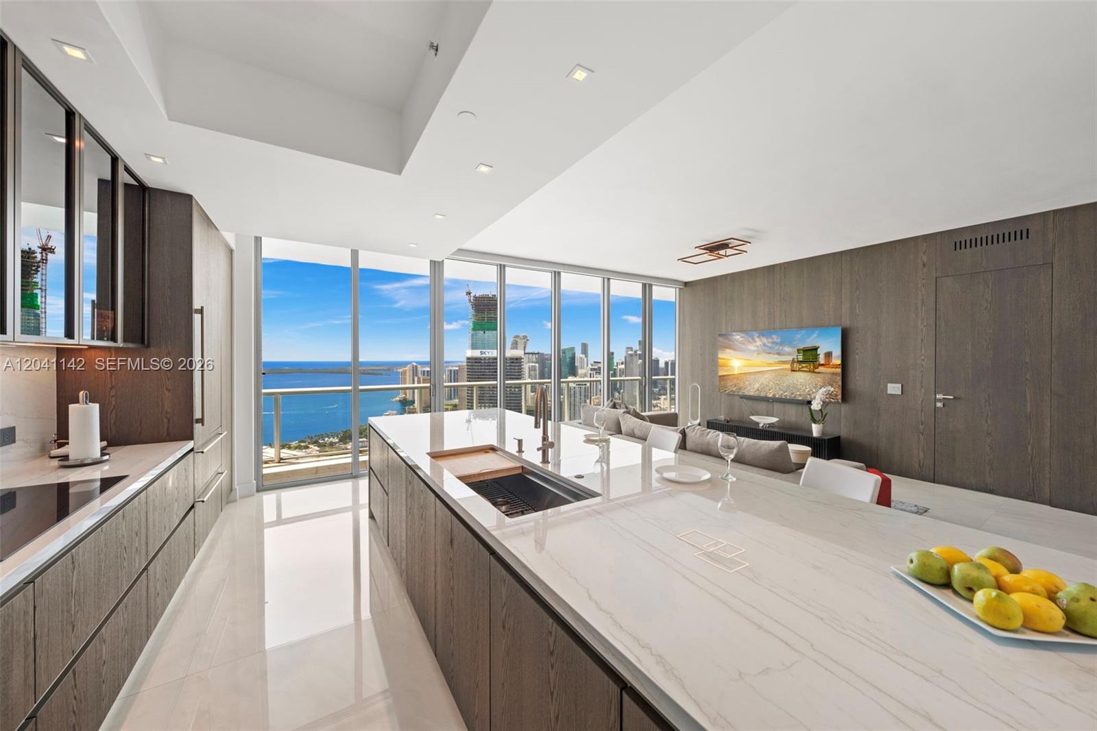 A modern kitchen with a large island overlooks a high-rise view of the ocean — 888 Biscayne Blvd # 5404, Miami FL 33132, MIAMI, FL