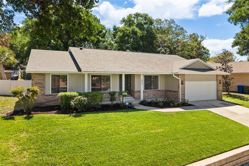A single-story house with a brick and siding exterior, a shingled roof, and a driveway — 925 RED DANDY DRIVE, ORLANDO, FL