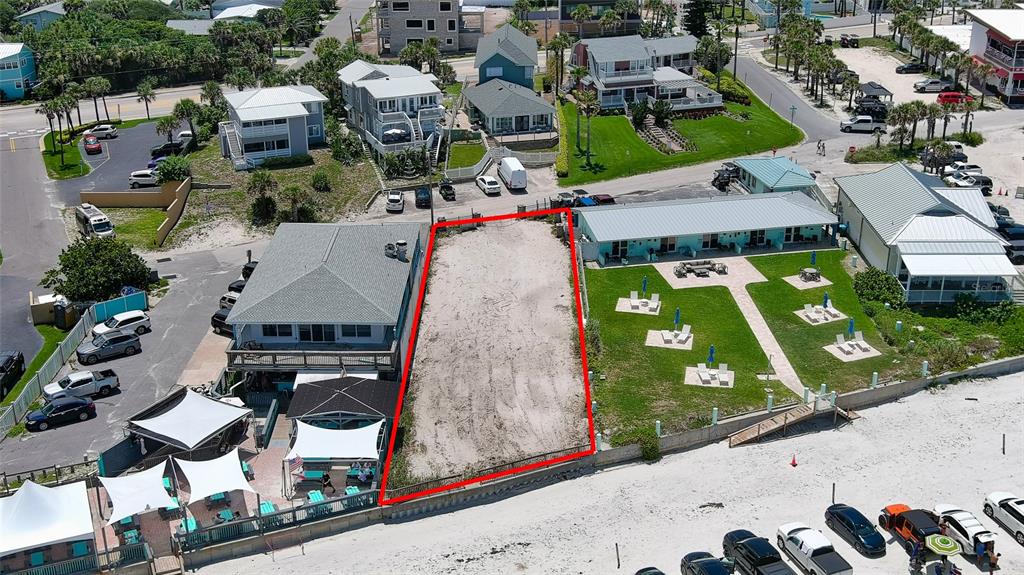 An aerial view shows a vacant sandy lot outlined in red between two beachside buildings — 0 BUENOS AIRES AVENUE, NEW SMYRNA BEACH, FL