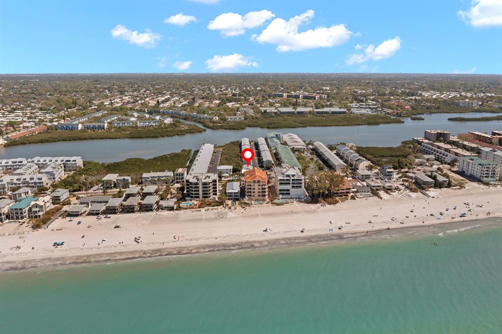 An aerial view shows a beachfront condominium complex with a red pin marking a building — 19823 GULF BOULEVARD UNIT 45, INDIAN SHORES, FL