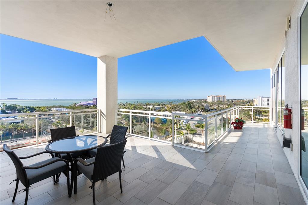 An exterior view of a modern high-rise condominium building at dusk with an arrow pointing — 540 N TAMIAMI TRAIL UNIT 702, SARASOTA, FL