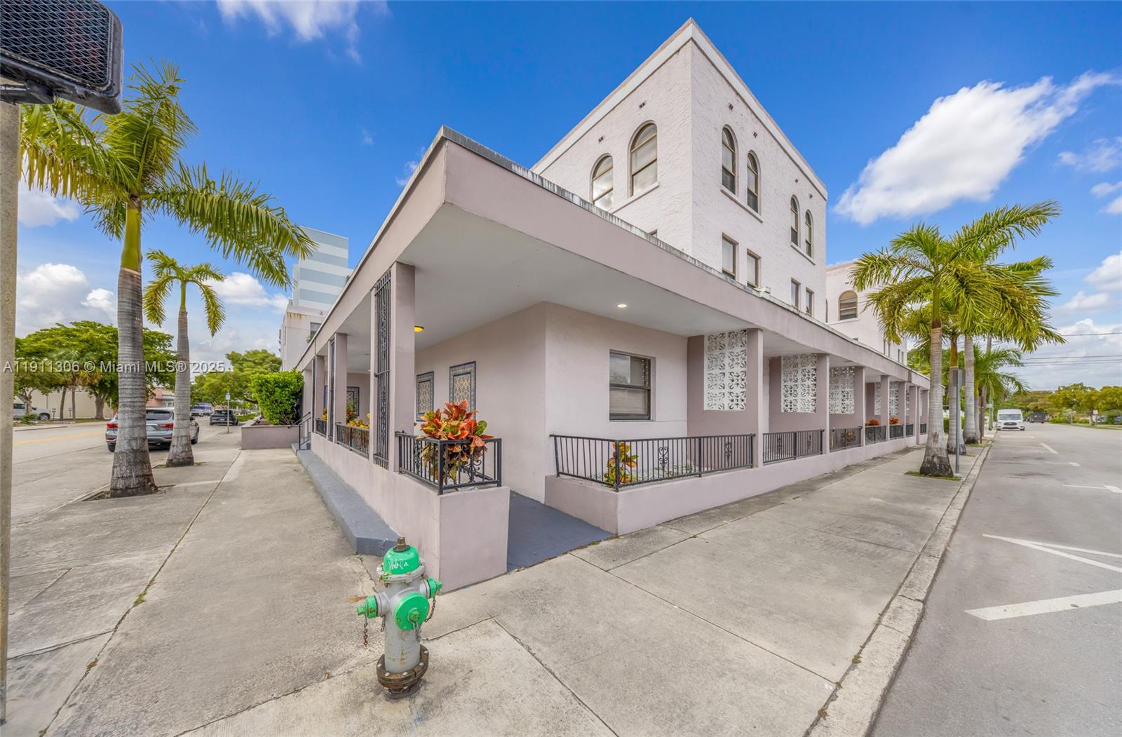 A light-colored multi-story building features a covered walkway with decorative screens and a fire hydrant — 2001 Polk St, Hollywood FL 33020, HOLLYWOOD, FL