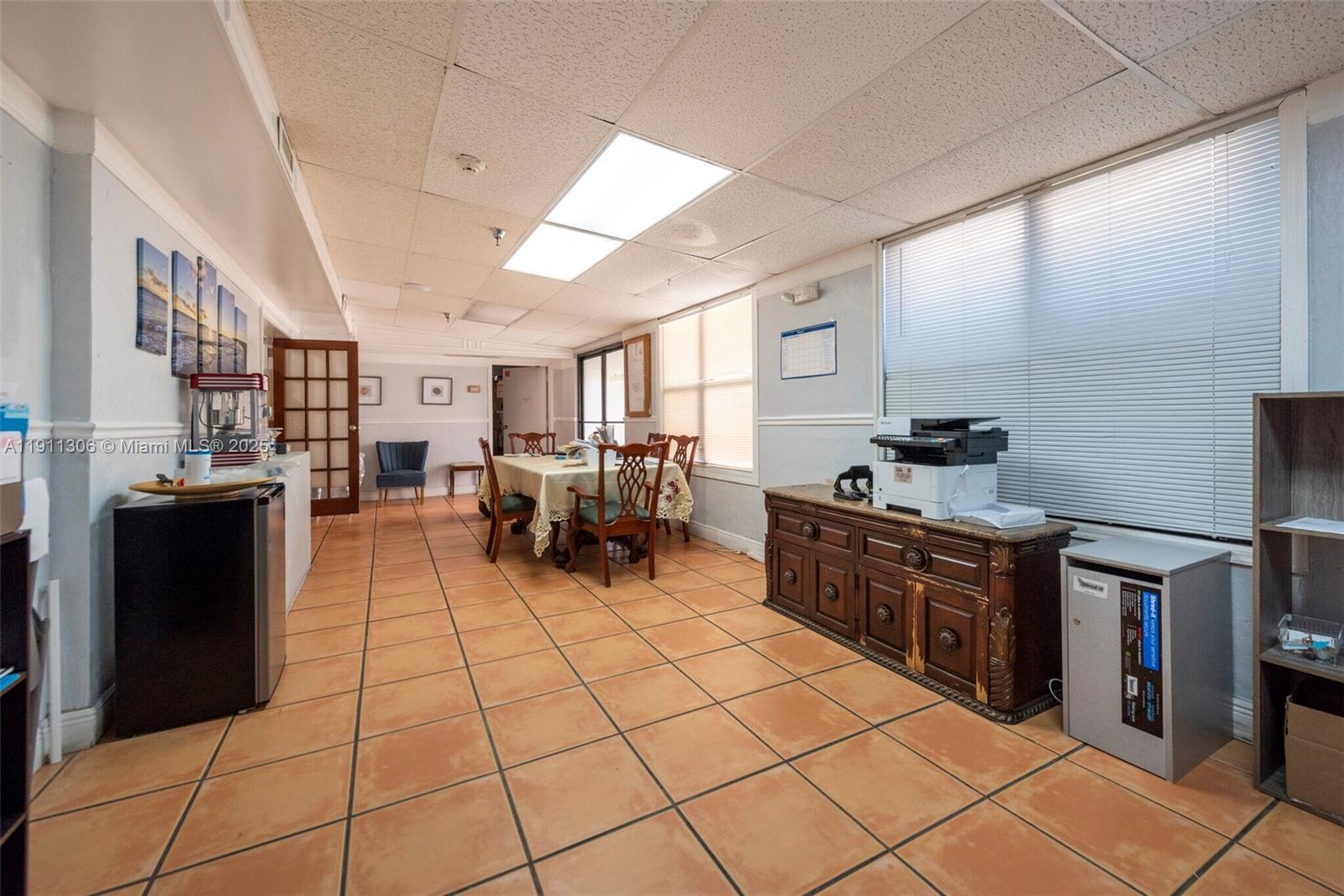 This room features tiled floors, a drop ceiling, a dining table, and office equipment — 2001 Polk St, Hollywood FL 33020, HOLLYWOOD, FL