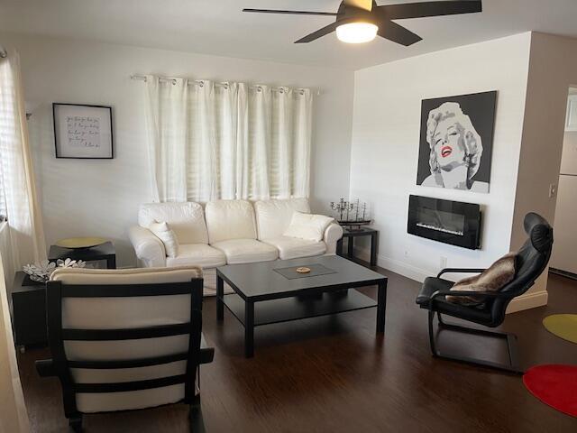 A living room features a white sofa, black coffee table, fireplace, and Marilyn Monroe wall art — 123 Kent # H, West Palm Beach FL 33417, WEST PALM BEACH, FL