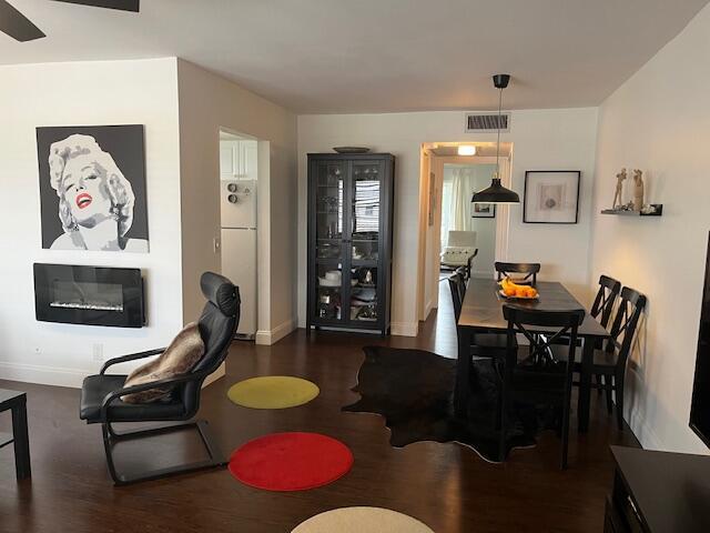 A dining area and living space feature dark wood floors, a fireplace, and modern furniture — 123 Kent # H, West Palm Beach FL 33417, WEST PALM BEACH, FL