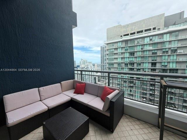 A balcony features a dark wicker sectional sofa with light cushions and a matching coffee table — 60 SW 13th St # 4810, Miami FL 33130, MIAMI, FL