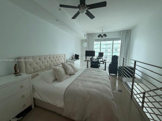 A bedroom with a tufted headboard, ceiling fan, and a lofted workspace overlooking a window — 60 SW 13th St # 4810, Miami FL 33130, MIAMI, FL