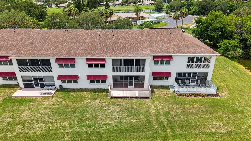 An aerial view of the rear of a multi-story apartment building with screened-in balconies — 1400 WATER VIEW DRIVE W UNIT 102, LARGO, FL
