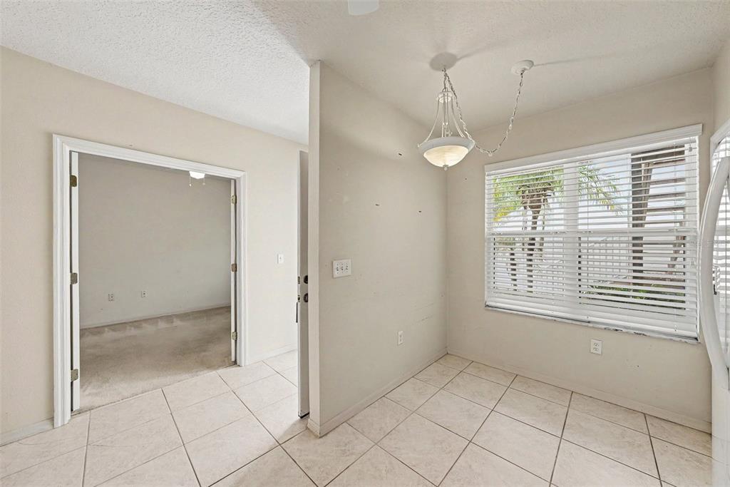 A tiled dining area features a hanging light fixture and a window with white blinds — 1400 WATER VIEW DRIVE W UNIT 102, LARGO, FL