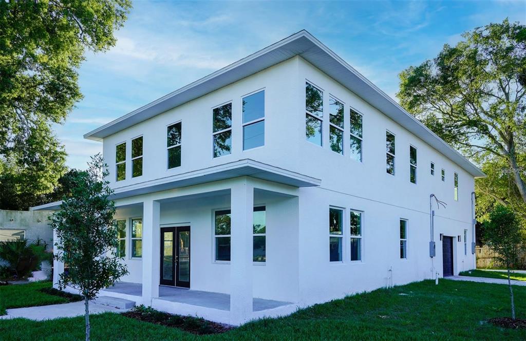 A two-story white house with a covered front porch and multiple windows on a lawn — 4710 21ST STREET N, ST PETERSBURG, FL