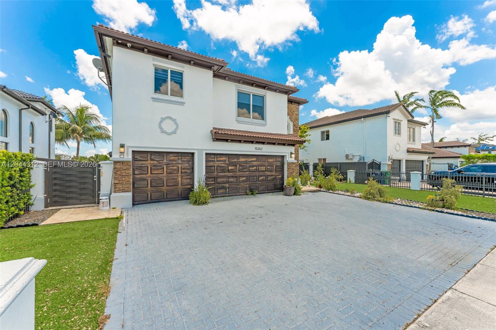 A two-story house features a paved driveway, two garage doors, and a white stucco exterior — 15262 SW 11th St, Miami FL 33194, MIAMI, FL