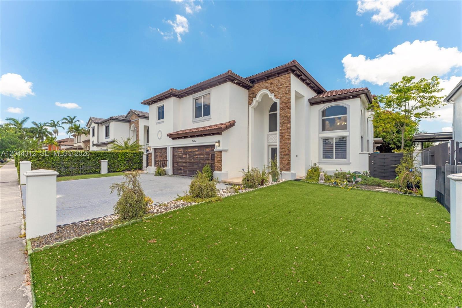 A two-story house with a white stucco exterior, stone accents, and a paved driveway — 15262 SW 11th St, Miami FL 33194, MIAMI, FL