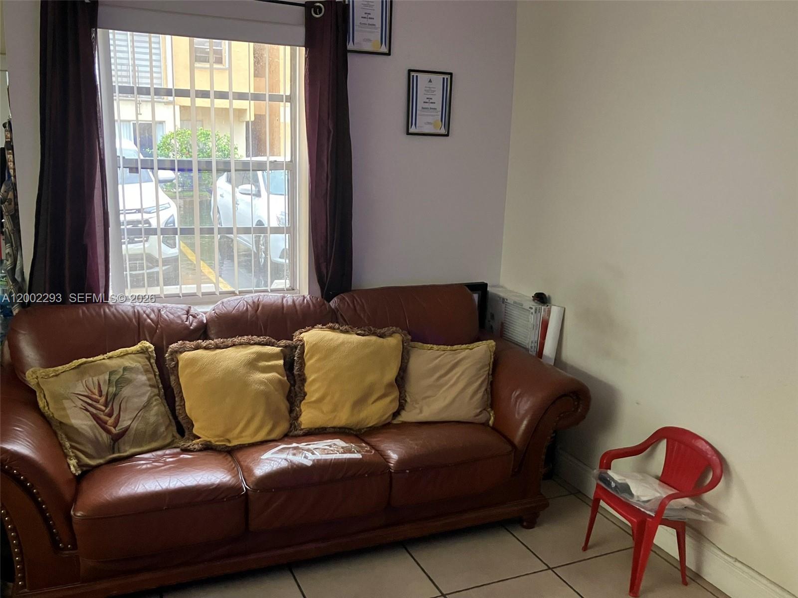 A brown leather sofa sits in a room with tiled floors and a window view — 9311 SW 4th St # 104B, Miami FL 33174, MIAMI, FL