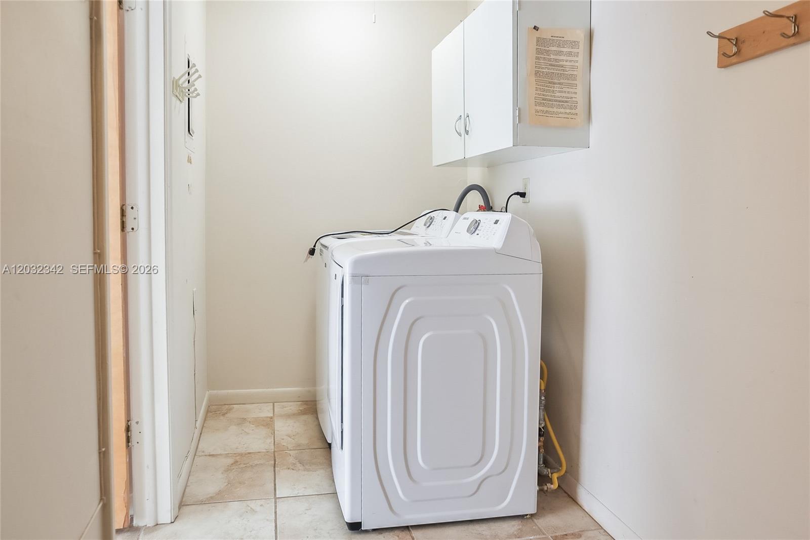 A laundry room features white appliances, tiled flooring, and a wall-mounted cabinet — 11521 SW 109th Rd # 10A, Miami FL 33176, MIAMI, FL