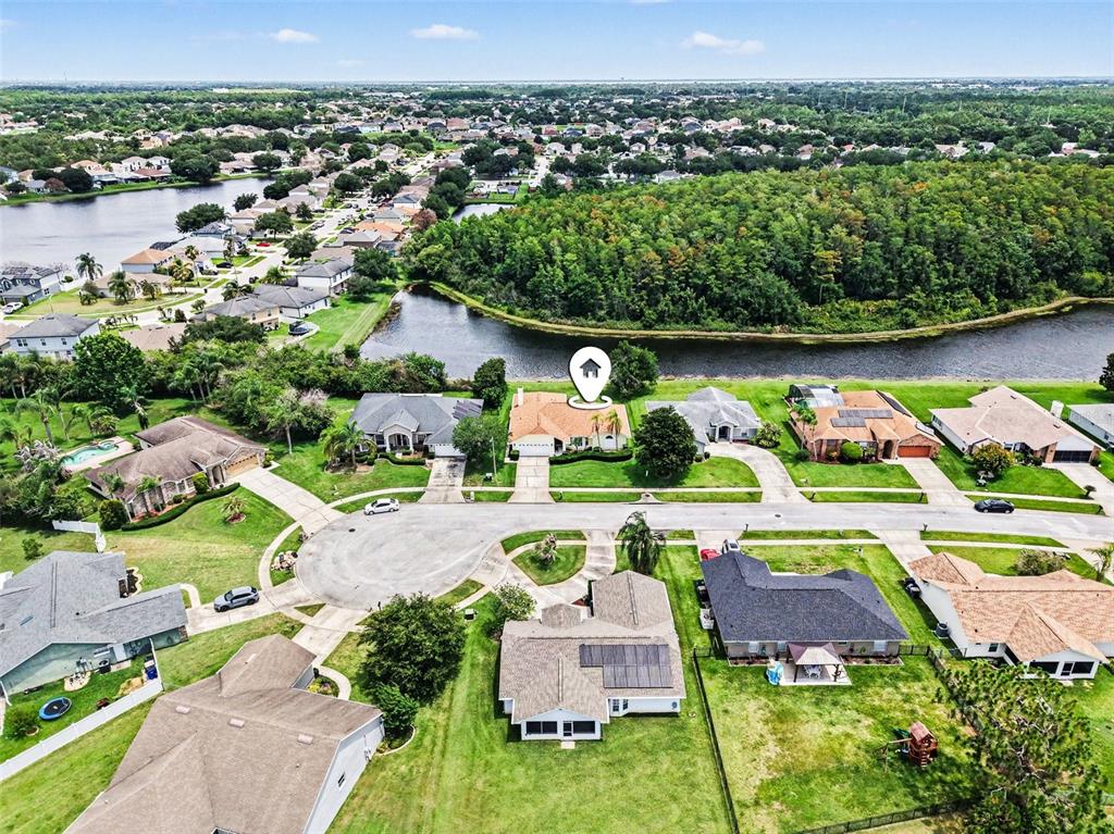 An aerial view shows a suburban neighborhood with houses, a pond, and green space — 2236 SUMMER RAYE COURT, ST CLOUD, FL