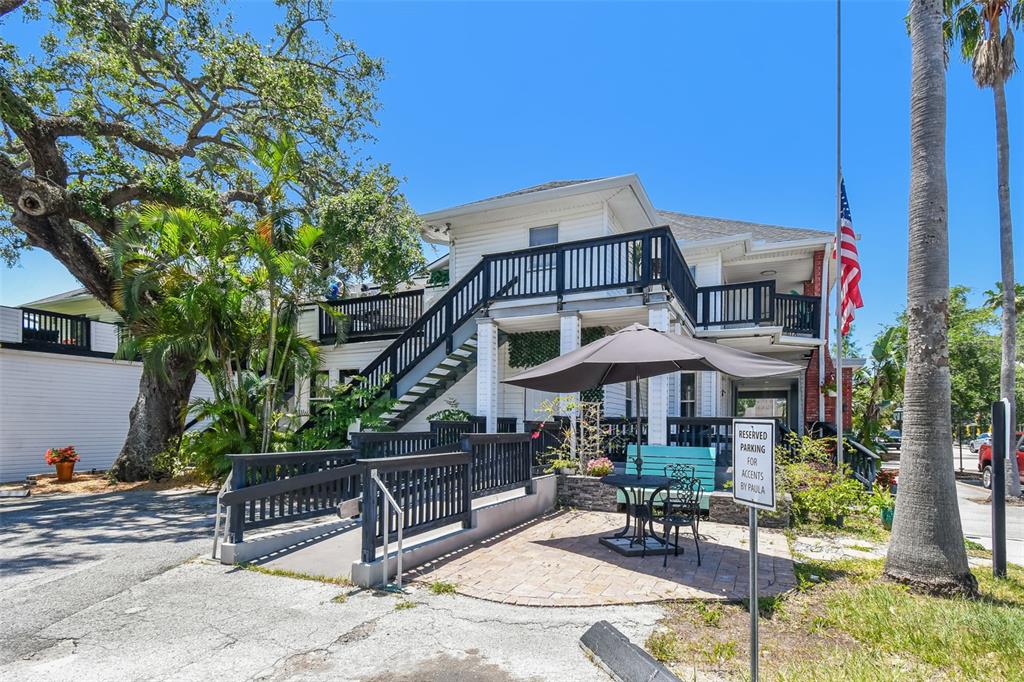 A two-story white building with an exterior staircase, a patio, and a reserved parking sign — 454 MAIN STREET, SAFETY HARBOR, FL
