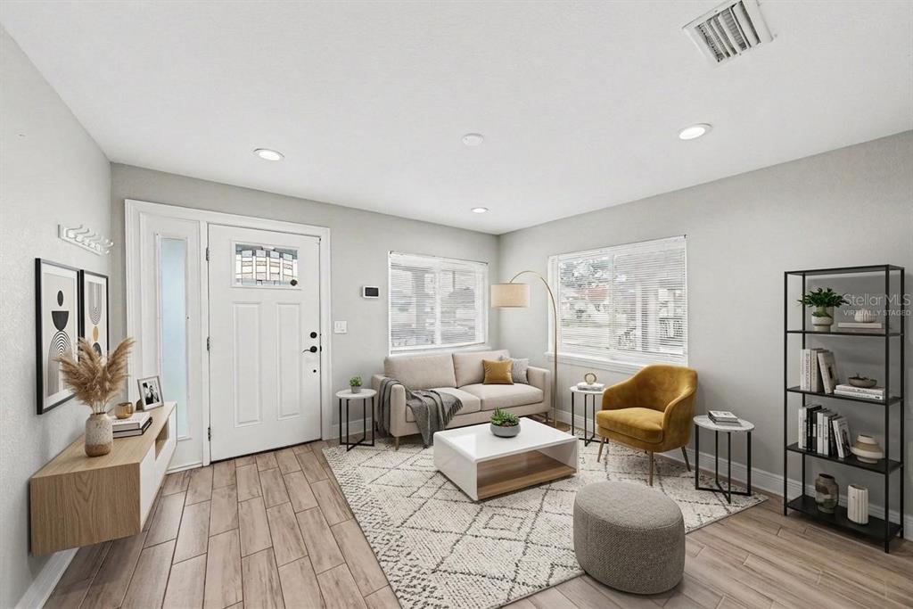 A kitchen features white cabinets, stainless steel appliances, quartz countertops, and wood-look tile flooring — 2619 W ST CONRAD, TAMPA, FL