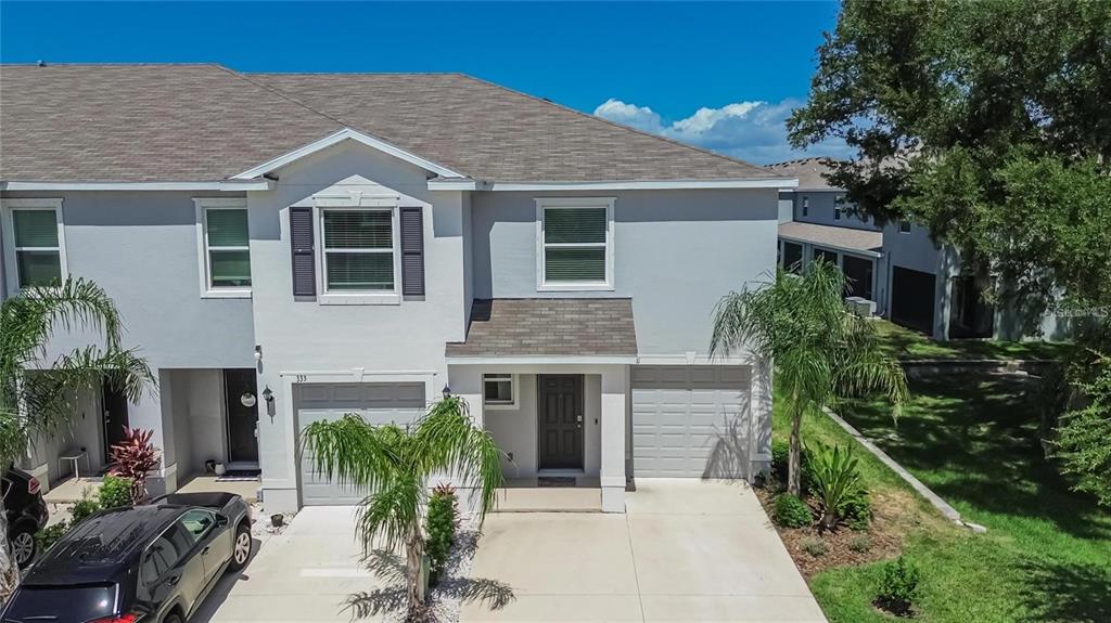 An exterior view of a two-story townhouse with a gray facade and two garage doors — 331 MANGROVE SHADE CIRCLE, APOLLO BEACH, FL