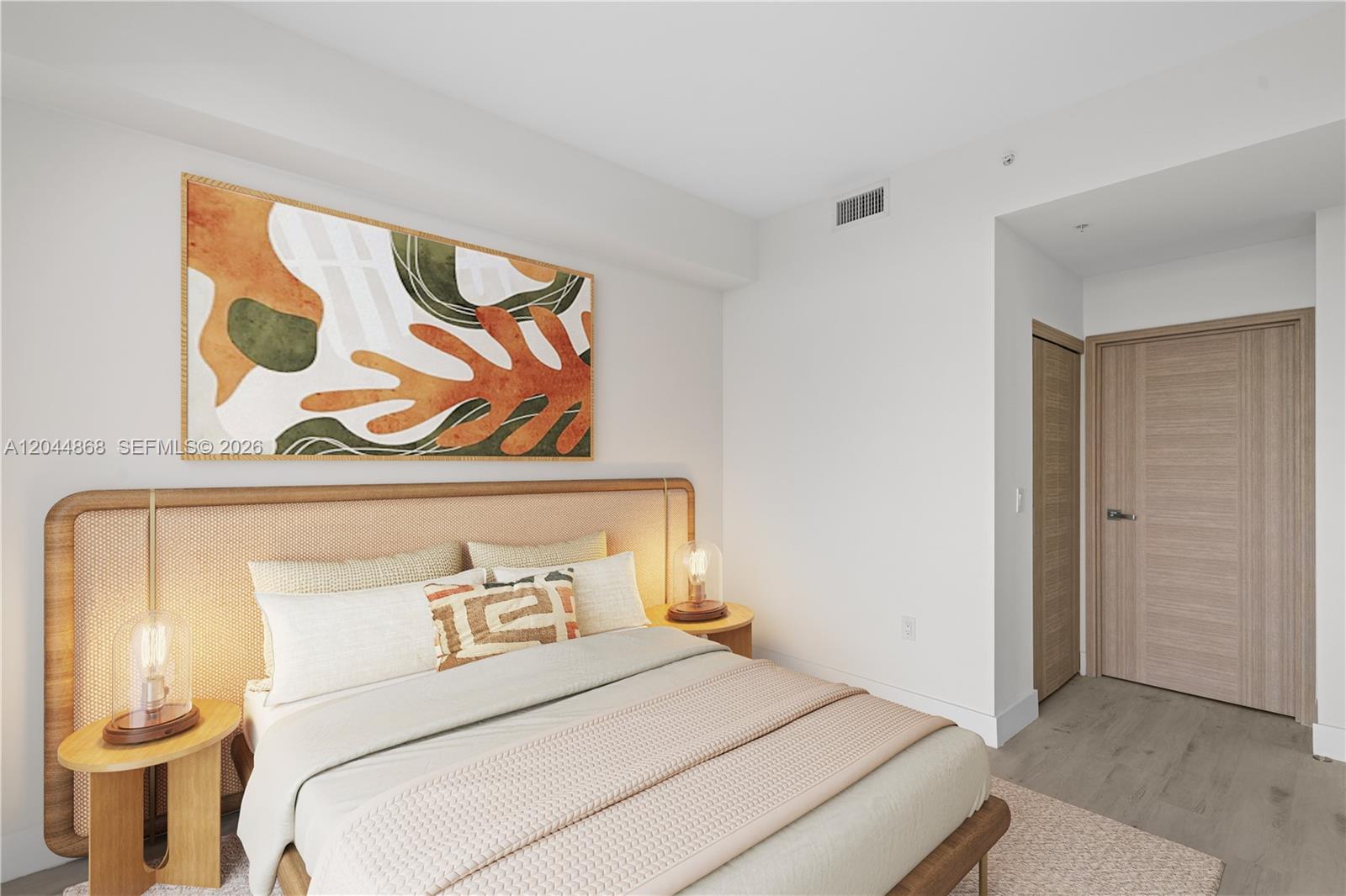 A bedroom features a rattan headboard, abstract wall art, and light wood finishes — 1601 SW 32 Avenue # 510, Miami FL 33145, MIAMI, FL
