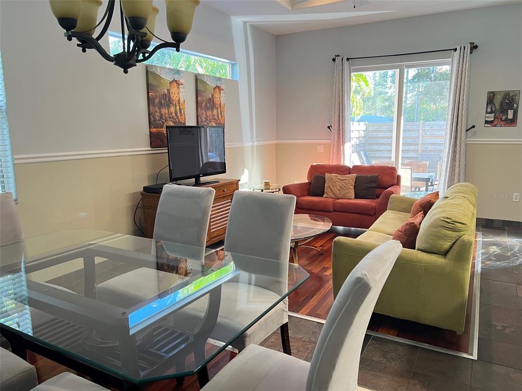 A dining area with a glass table overlooks a living room featuring two sofas — 2043 ROSELAWN STREET, SARASOTA, FL
