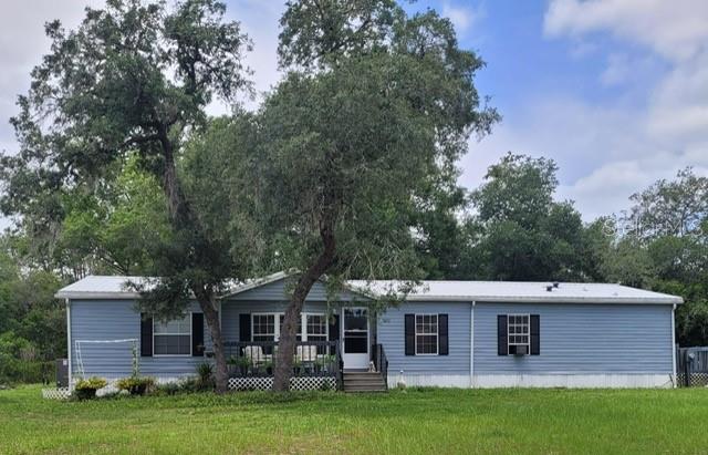 A light blue single-story manufactured home with a metal roof sits on a grassy lot — 9070 SE 196TH TERRACE, OCKLAWAHA, FL