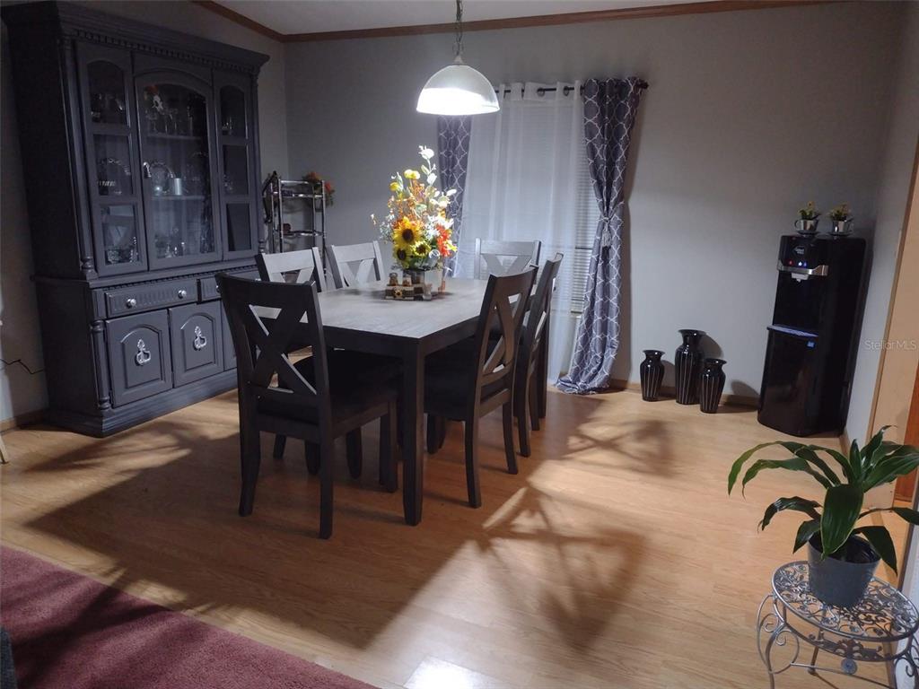 A dining room features a dark wood table and chairs, a hutch, and light flooring — 9070 SE 196TH TERRACE, OCKLAWAHA, FL