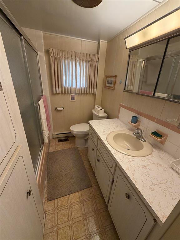 A bathroom features a vanity with a laminate countertop, a toilet, and a shower stall — 5121 9TH STREET W, BRADENTON, FL