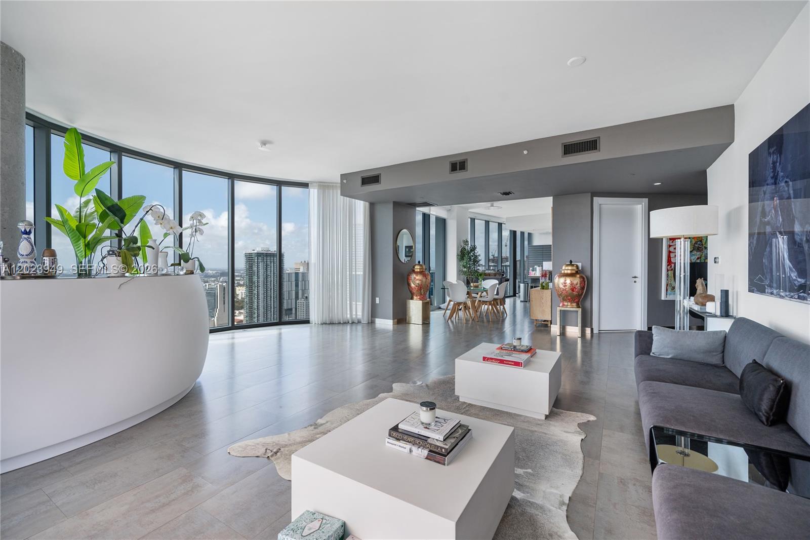 A modern living room features floor-to-ceiling windows, gray tile flooring, and two white coffee tables — 200 Biscayne Boulevard Way # 4902, Miami FL 33131, MIAMI, FL