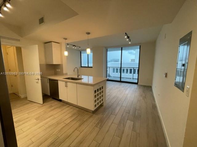 A modern kitchen with white cabinets, a central island, and wood-look tile flooring — 999 SW 1st Ave # 3115, Miami FL 33130, MIAMI, FL