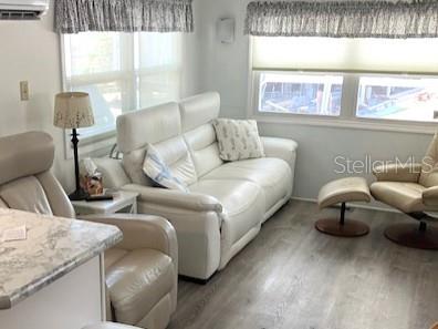 A living room features a white leather sofa, matching armchairs, and light wood-look flooring — 800 CHESAPEAKE DRIVE UNIT 42, TARPON SPRINGS, FL