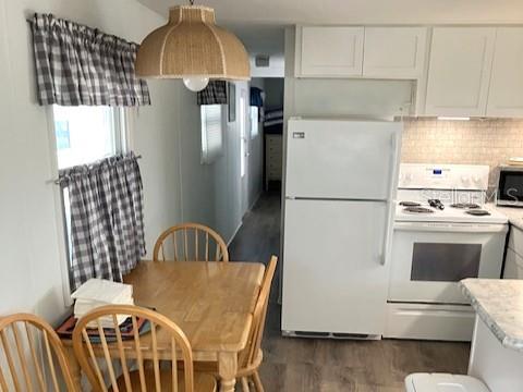 A kitchen with white cabinets, a white refrigerator, a white stove, and a dining table — 800 CHESAPEAKE DRIVE UNIT 42, TARPON SPRINGS, FL