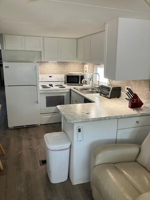 A kitchen features white cabinets, a white refrigerator, a stove, and a light-colored countertop — 800 CHESAPEAKE DRIVE UNIT 42, TARPON SPRINGS, FL