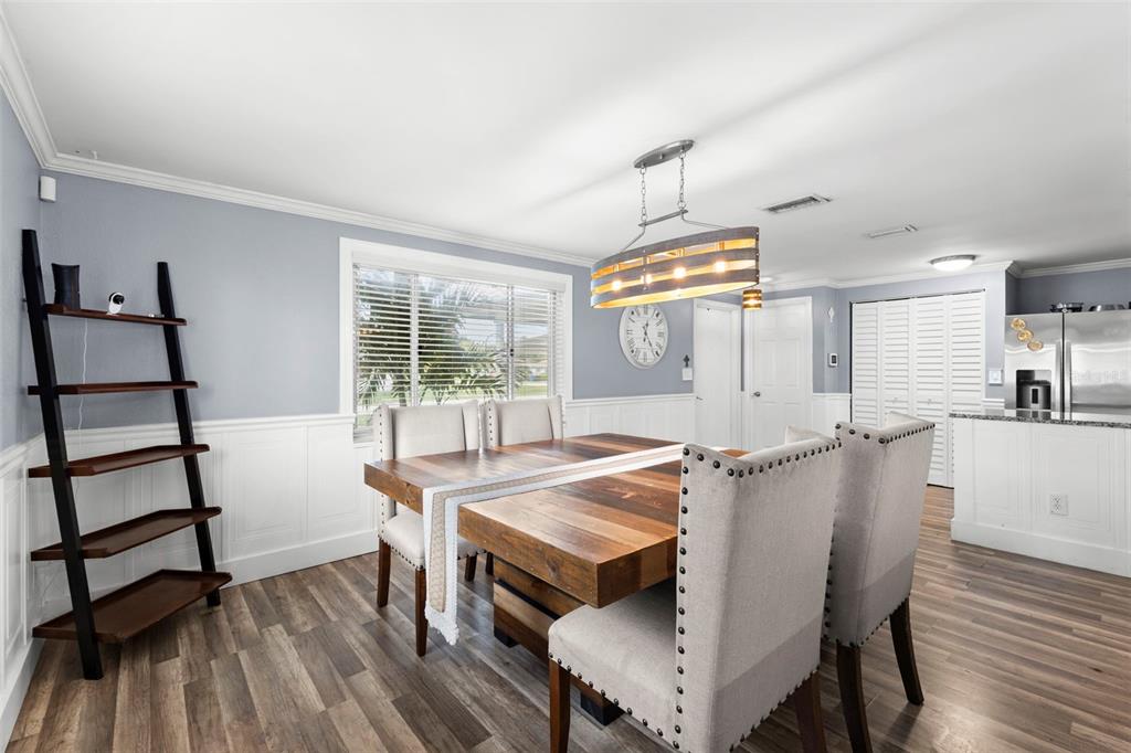 A dining room with a wooden table, bench seating, and light blue walls with wainscoting — 5210 6TH STREET S, ST PETERSBURG, FL