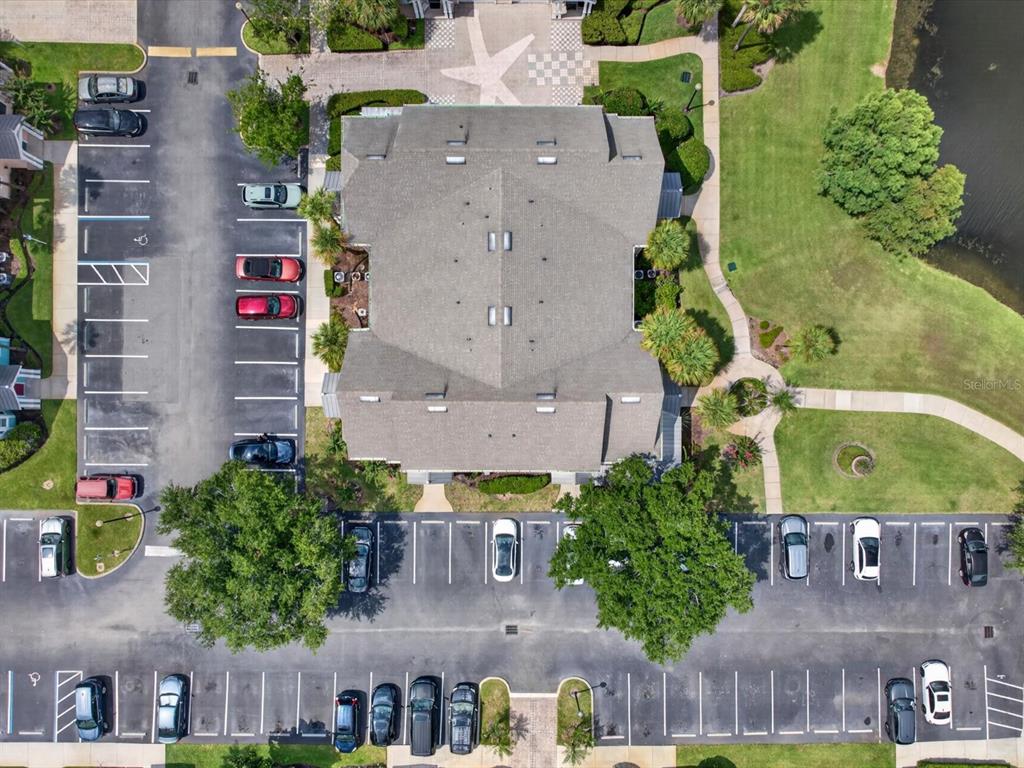 An aerial view shows a multi-unit building surrounded by parking lots and green space — 3003 LIMBO LANE UNIT #103, KISSIMMEE, FL