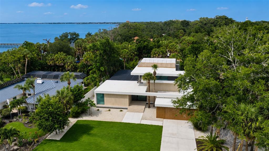 An aerial view shows a modern house with a flat roof and a large lawn — 359 N SHORE DRIVE, SARASOTA, FL