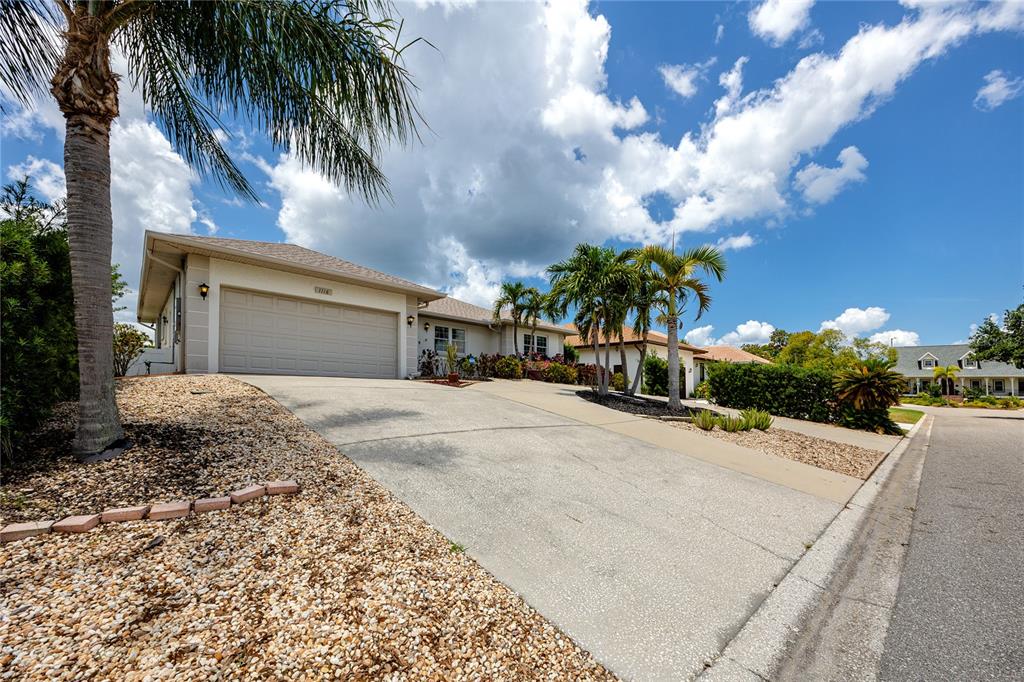A single-story house with a beige exterior, a two-car garage, and palm trees — 1116 KINGFISH PLACE, APOLLO BEACH, FL