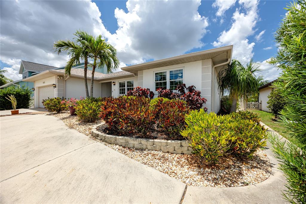 A single-story house with a concrete driveway, palm trees, and a landscaped front garden — 1116 KINGFISH PLACE, APOLLO BEACH, FL