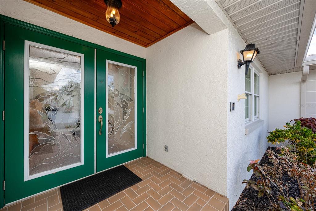 A covered entryway features a green double door with glass inserts and a tiled floor — 1116 KINGFISH PLACE, APOLLO BEACH, FL