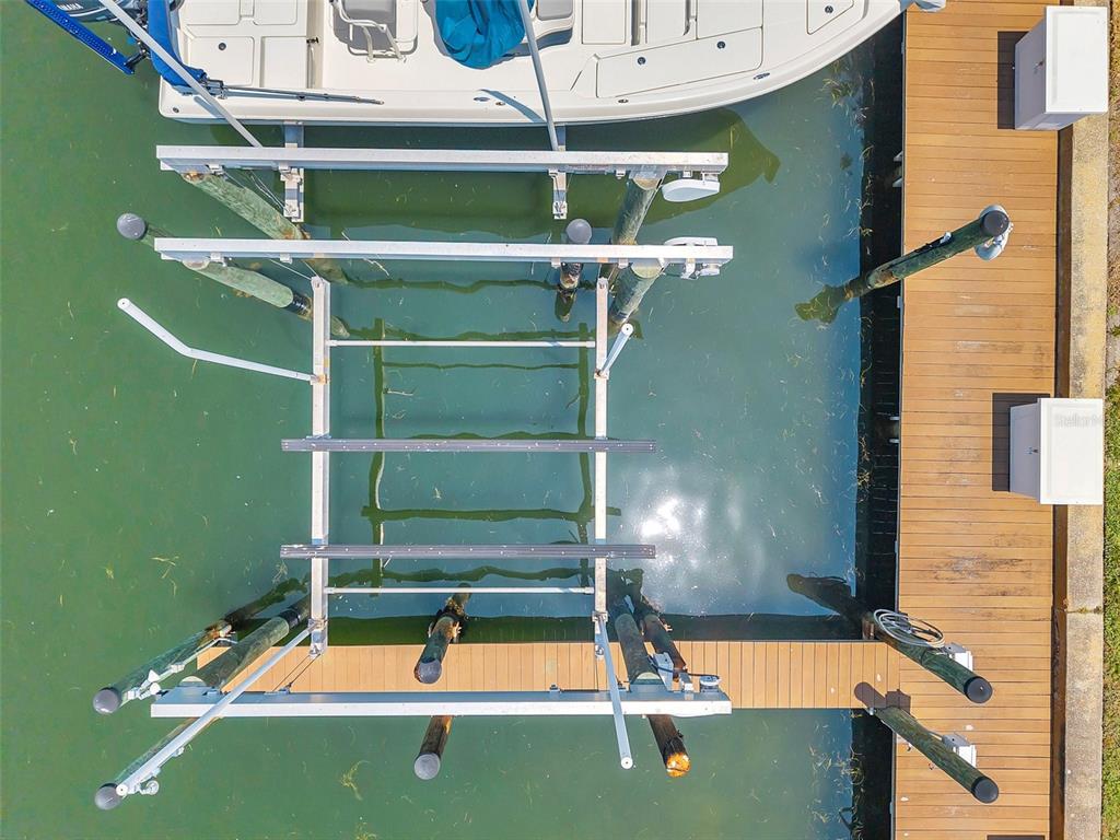 An aerial view shows a boat lift positioned next to a wooden dock in water — 0 #114SS COQUINA KEY DRIVE SE UNIT 114SS, ST PETERSBURG, FL