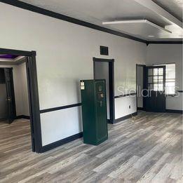 An interior room features light-colored walls with dark trim, wood-look flooring, and a green safe — 3100 EUNICE AVENUE, ORLANDO, FL