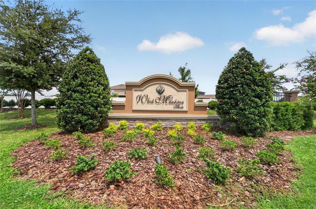 A neighborhood entrance sign for Wind Meadows South sits in a landscaped garden bed — 4450 COZY CONDOR COURT, BARTOW, FL