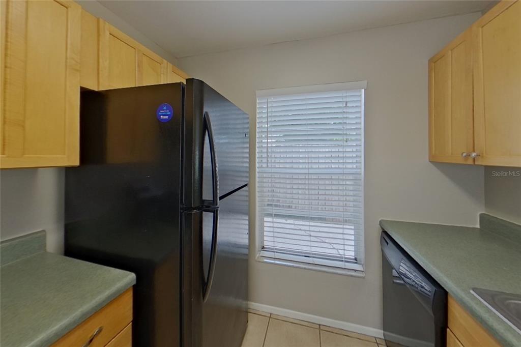 A kitchen features light wood cabinets, green countertops, a black refrigerator, and a window — 13311 LARAWAY DRIVE, RIVERVIEW, FL