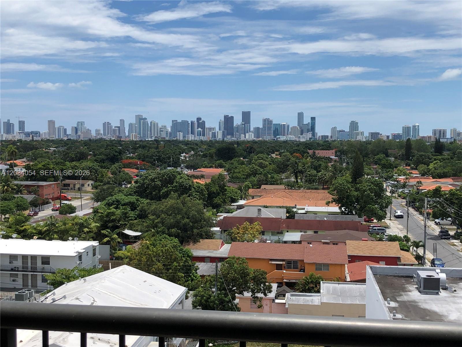An elevated view shows a residential neighborhood with a distant city skyline under a blue sky — 1690 SW 27th Ave # 803, Miami FL 33145, MIAMI, FL