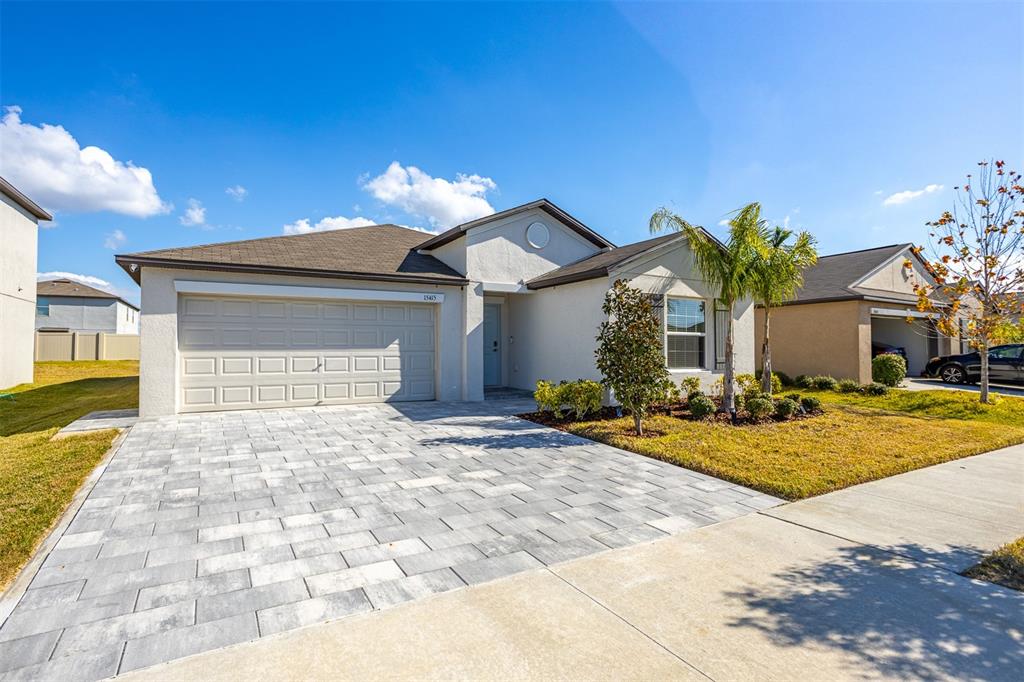 A modern open-concept living room and kitchen featuring a large gray sectional sofa — 15415 MILLER CREEK DRIVE, SUN CITY CENTER, FL