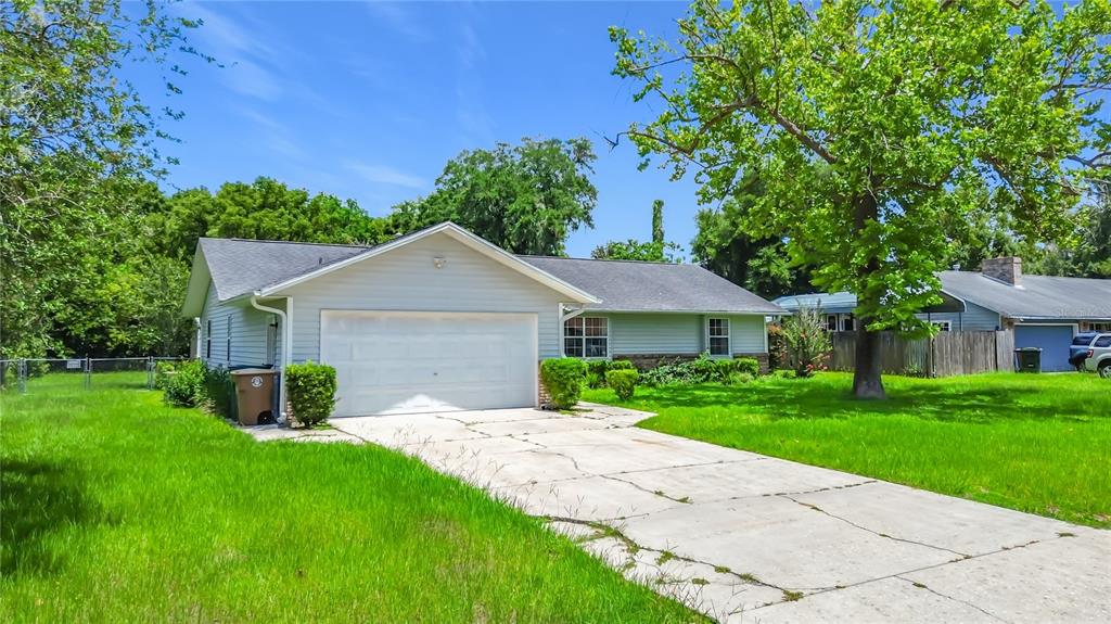 A single-story house with light siding, a two-car garage, and a concrete driveway — 707 NE 46TH COURT, OCALA, FL